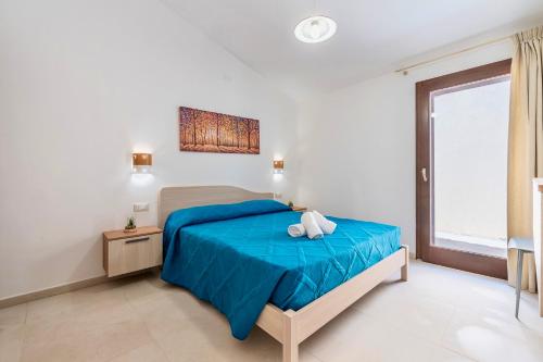 a bedroom with a blue bed and a window at Villa with private pool in San Teodoro just few minutes from La Cinta - beach in San Teodoro