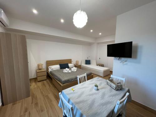 a bedroom with a bed and a table and a tv at Trinacria apartments Falcone in Falcone