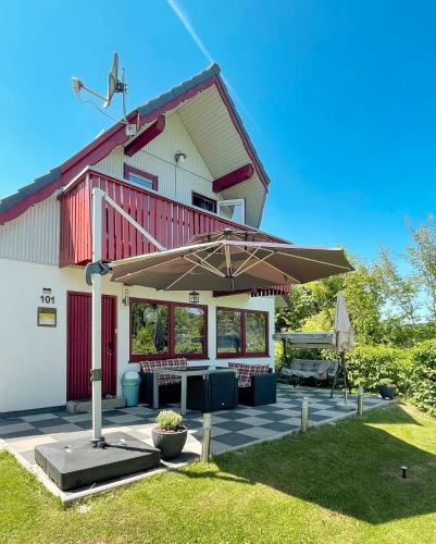 a house with a patio with an umbrella at Ferienhaus "Gestiefelter Kater" am See im Bergland in Kirchheim