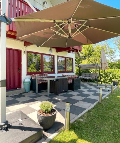a patio with a table and a large umbrella at Ferienhaus "Gestiefelter Kater" am See im Bergland in Kirchheim