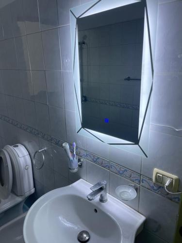un baño con lavabo y espejo en City Center, en Durrës