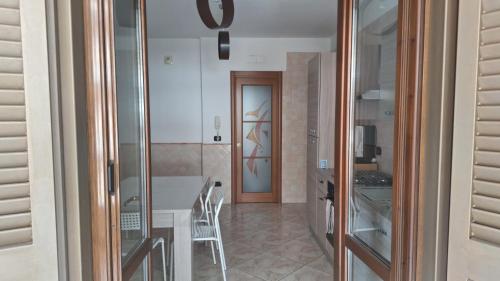 a kitchen with a table and a glass door at dolce dimora in Pagani