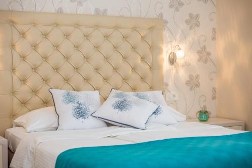 a bedroom with a white bed with blue and white pillows at Apartments & Rooms Milcetic M in Malinska