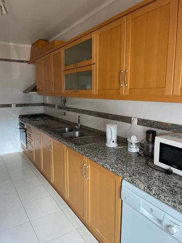 a kitchen with wooden cabinets and a sink at Live in Abrantes in Abrantes