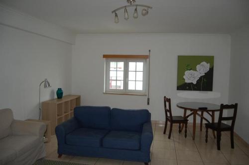 a living room with a blue couch and a table at Live in Abrantes in Abrantes