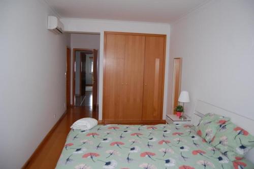 a bedroom with a large bed with a floral bedspread at Live in Abrantes in Abrantes