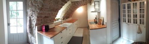 une salle de bain avec un lavabo et un mur en pierre dans l'établissement Maison de caractère, à Chambonas