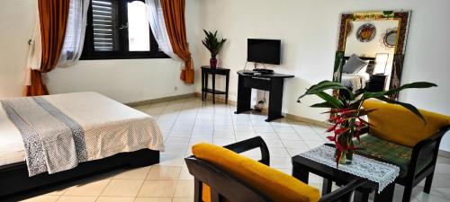 a bedroom with a bed and a chair and a mirror at Villa Oasis Abidjan in Abidjan