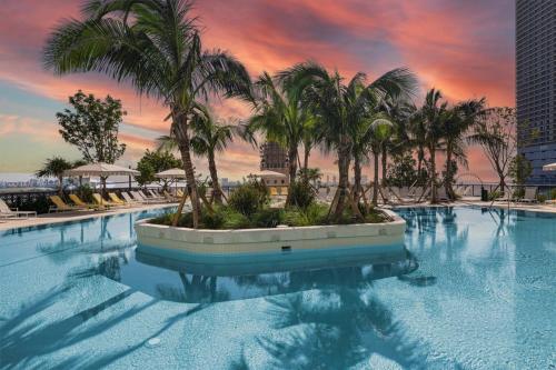 a large swimming pool with palm trees in a city at Condo Downtown in Miami