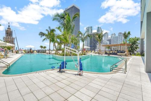 a large swimming pool with palm trees and buildings at Condo Downtown in Miami