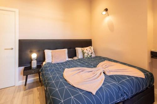 Un dormitorio con una cama con un edredón azul. en Elegant Escape Eastbourne, en Eastbourne