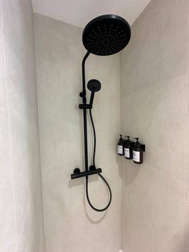 La salle de bains est pourvue d'une douche avec un pommeau de douche noir. dans l'établissement Suite by CollectionAura Centre Charleville, à Charleville-Mézières