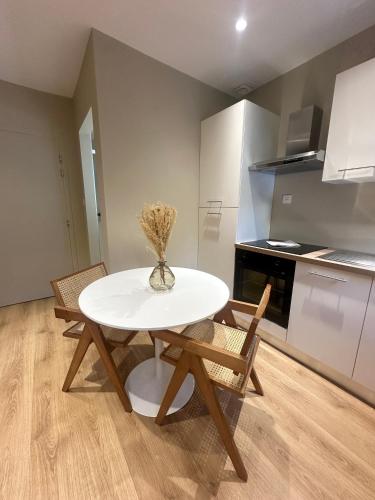 une table blanche et des chaises dans une cuisine dans l'établissement Suite by CollectionAura Centre Charleville, à Charleville-Mézières