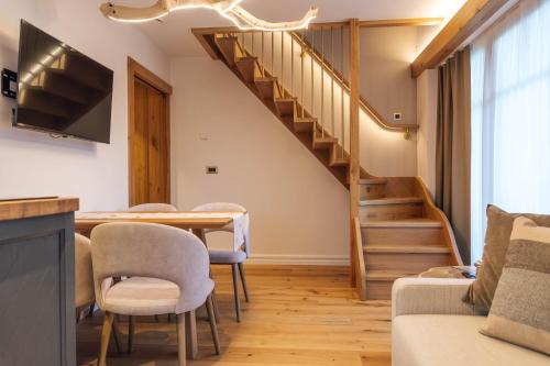 a living room with a dining room table and a staircase at Menart Estate in Cerklje na Gorenjskem