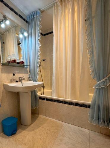 a bathroom with a sink and a shower with a tub at Tropicana in Benicàssim