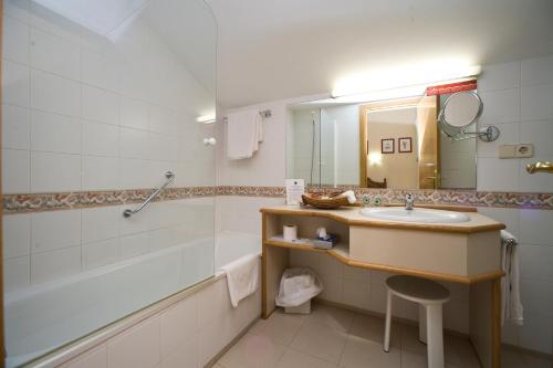 a bathroom with a sink and a tub and a mirror at Hotel Ekai in Ecay