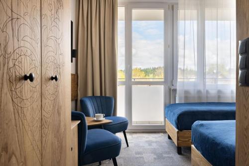 a hotel room with two beds and a window at Hotel Rzemieślnik Zakopane in Zakopane