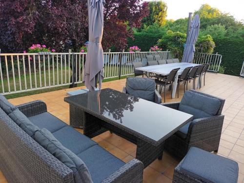 un patio avec une table, des chaises et des parasols dans l'établissement Gite Au Nom Des Dames, à Faverolles-sur-Cher