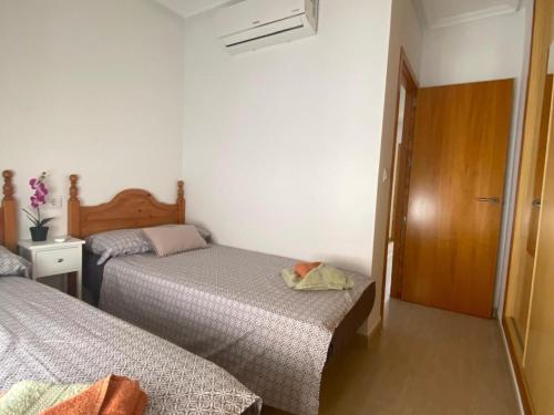 ein kleines Schlafzimmer mit 2 Betten und einer Tür in der Unterkunft Casa a 200m de la playa en San Juan de los Terreros - ES-376-12 in Pulpí