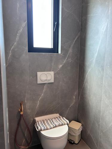 a bathroom with a white toilet and a mirror at Escape Suites in Dhërmi