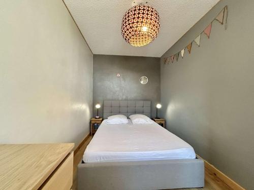 une chambre avec un lit et un lustre dans l'établissement Appartement 2 pièces avec coin montagne à Praz-Sur-Arly - 6 personnes - FR-1-603-126, à Praz-sur-Arly