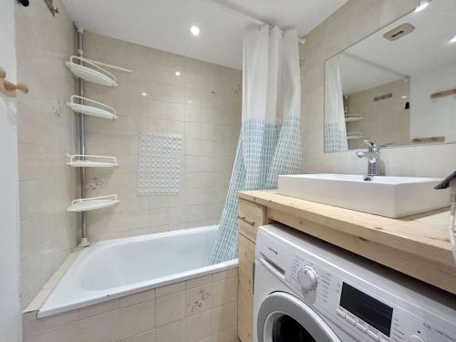 La salle de bains est pourvue d'une baignoire, d'un lavabo et d'un lave-linge. dans l'établissement Appartement 2 pièces avec coin montagne à Praz-Sur-Arly - 6 personnes - FR-1-603-126, à Praz-sur-Arly