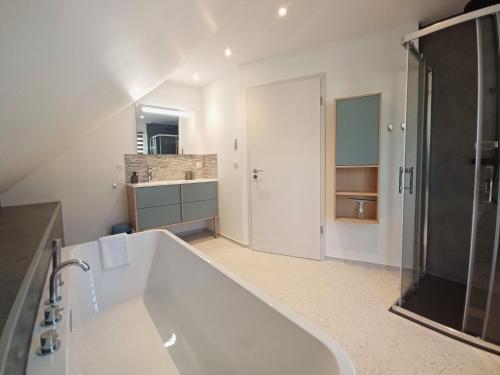 ein großes weißes Badezimmer mit Badewanne und Dusche in der Unterkunft Maison neuve 4 chambres à Soulzbach - FR-1-744-46 in Soultzbach-les-Bains