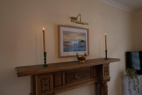 a mantle with two candles and a picture on the wall at Cottage in Central Burbage Leicestershire in Burbage