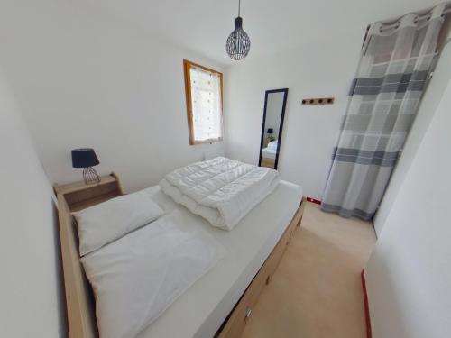 ein kleines Schlafzimmer mit einem Bett und einem Spiegel in der Unterkunft Appartement 2 chambres avec balcon près des pistes aux Rousses - FR-1-834-2 in Les Rousses