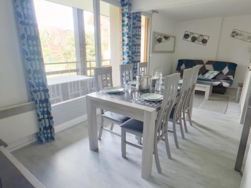 une salle à manger avec une table et des chaises blanches dans l'établissement Charmant appartement aux Rousses pour 6 pers. - FR-1-834-2, aux Rousses