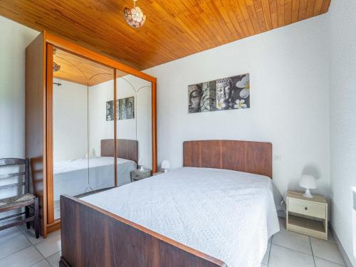une chambre avec un grand lit et un miroir dans l'établissement Maison à Mimizan Plage Sud avec jardin pour 4 personnes - Ménage inclus - FR-1-50-182, à Mimizan