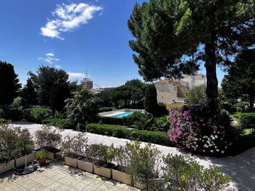 un jardin avec un arbre et quelques buissons et fleurs dans l'établissement Appartement 3 pièces proche plage et commerces avec garage - FR-1-702-74, au Cap d'Agde