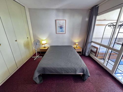 une chambre avec un lit et deux lampes et une fenêtre dans l'établissement Appartement 3 pièces proche plage et commerces avec garage - FR-1-702-74, au Cap d'Agde