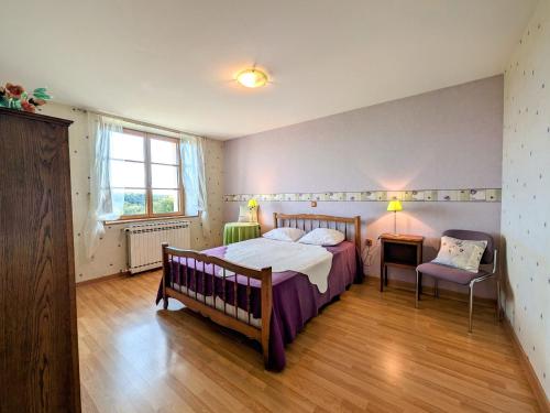 a bedroom with a bed and a table and a chair at Maison spacieuse près de Vesoul avec cheminée, idéale pour familles - FR-1-583-434 in Dampierre-sur-Linotte