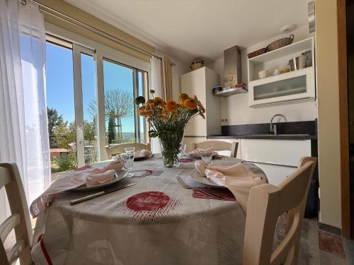 a dining room table with a vase of flowers on it at Maison de charme avec vue sur Excideuil, au calme - FR-1-839-1 in Saint-Médard-dʼExcideuil