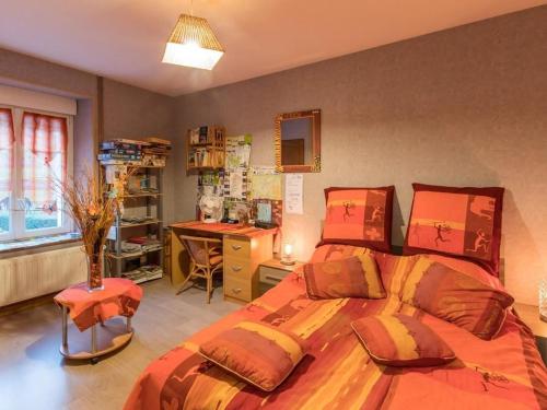 a bedroom with a bed and a desk in it at Gîte familial confortable près de Luxeuil-Les-Bains - FR-1-583-401 in Briaucourt