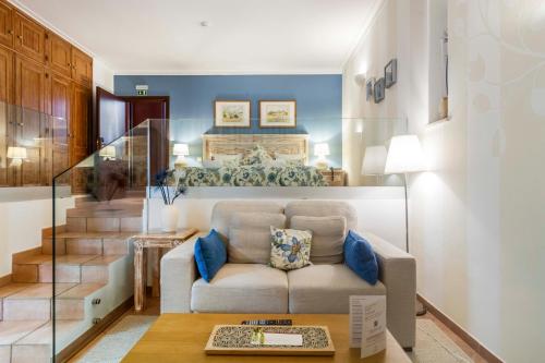 a living room with a couch and a staircase at Boutique Hotel Vivenda Miranda in Lagos