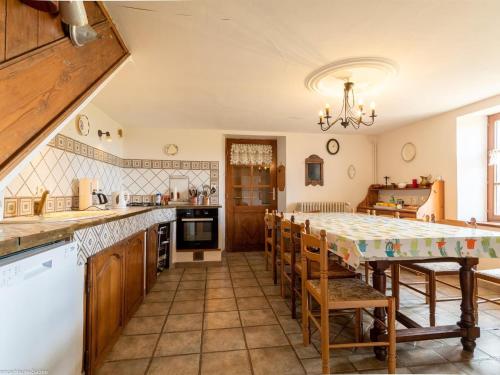 une grande cuisine avec une grande table et des chaises dans l'établissement Grande maison rénovée avec WIFI, idéale pour familles - FR-1-583-406, à La Vaivre