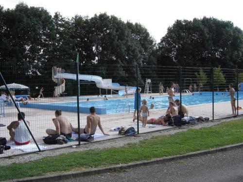 un groupe de personnes assises autour d'une piscine dans l'établissement Gîte authentique 5 pers avec cheminée et jardin - FR-1-583-424, à Ternuay-Melay-et-Saint-Hilaire