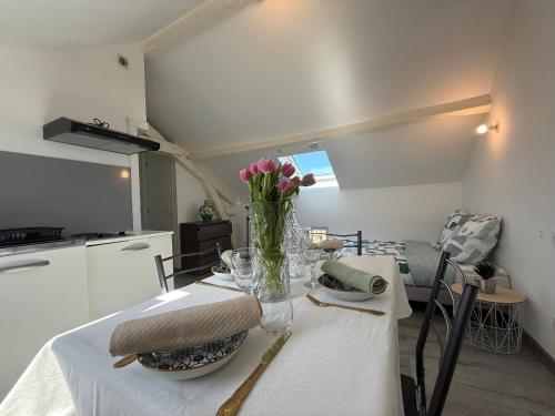 une table de salle à manger avec un vase de fleurs dessus dans l'établissement Studio cosy et rénové près de Périgueux avec Wifi et animaux admis - FR-1-839-4, à Savignac-les-Églises