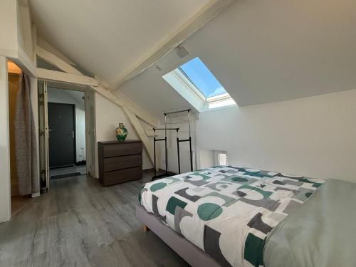 une chambre avec un lit et une lucarne dans l'établissement Studio cosy et rénové près de Périgueux avec Wifi et animaux admis - FR-1-839-4, à Savignac-les-Églises