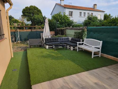 une terrasse avec un canapé, des chaises et un parasol dans l'établissement Le Frais Jus, à Fréjus