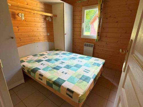 ein kleines Schlafzimmer mit einem Bett in einem Holzzimmer in der Unterkunft Chalet Campanules 37 - Nature, Randonnée & Famille - FR-1-583-471 in Mélisey