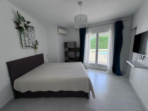 une chambre avec un lit et une grande fenêtre dans l'établissement Maison spacieuse avec piscine privée – Idéale pour familles - FR-1-732-109, à Latour-Bas-Elne