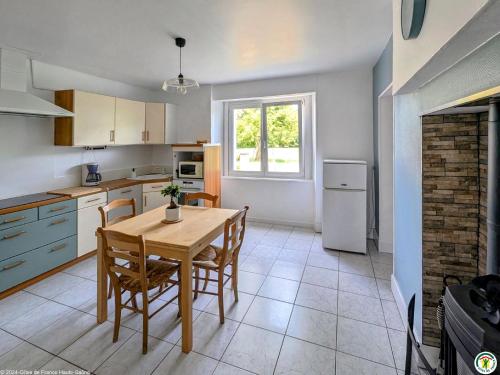 une cuisine avec une table et des chaises dans une cuisine dans l'établissement Gîte paisible à La Vernotte pour 4 personnes - FR-1-583-492, à La Vernotte