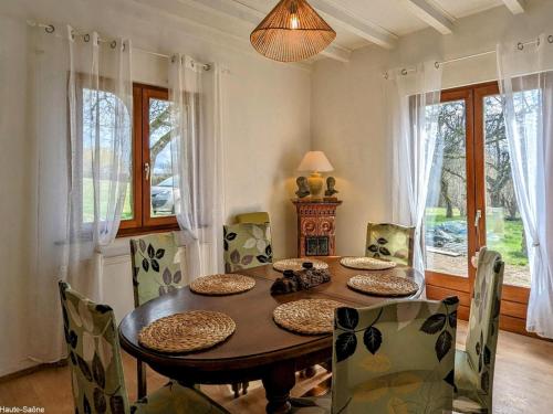 une salle à manger avec une table et des chaises en bois dans l'établissement Gîte familial avec jardin et parking à Héricourt, proche de Belfort - FR-1-583-497, à Héricourt