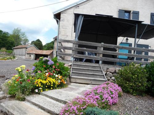 a building with a porch with flowers in front of it at Gîte La Chapelle Pleine Nature, Animaux Bienvenus - FR-1-583-420 in La Rosière