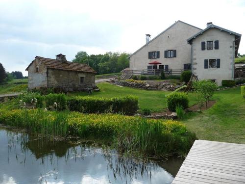 a house and a pond in front of a house at Gîte La Chapelle Pleine Nature, Animaux Bienvenus - FR-1-583-420 in La Rosière