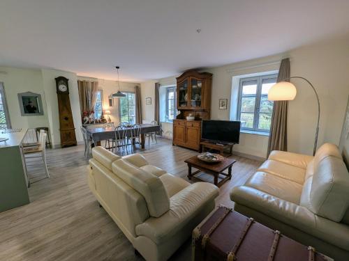 a living room with two couches and a tv at Maison de caractère à Gy avec parking et Wifi - FR-1-583-448 in Gy