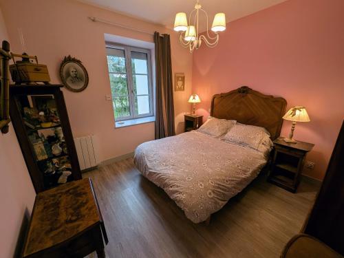 a bedroom with a bed and a window and a chandelier at Maison de caractère à Gy avec parking et Wifi - FR-1-583-448 in Gy